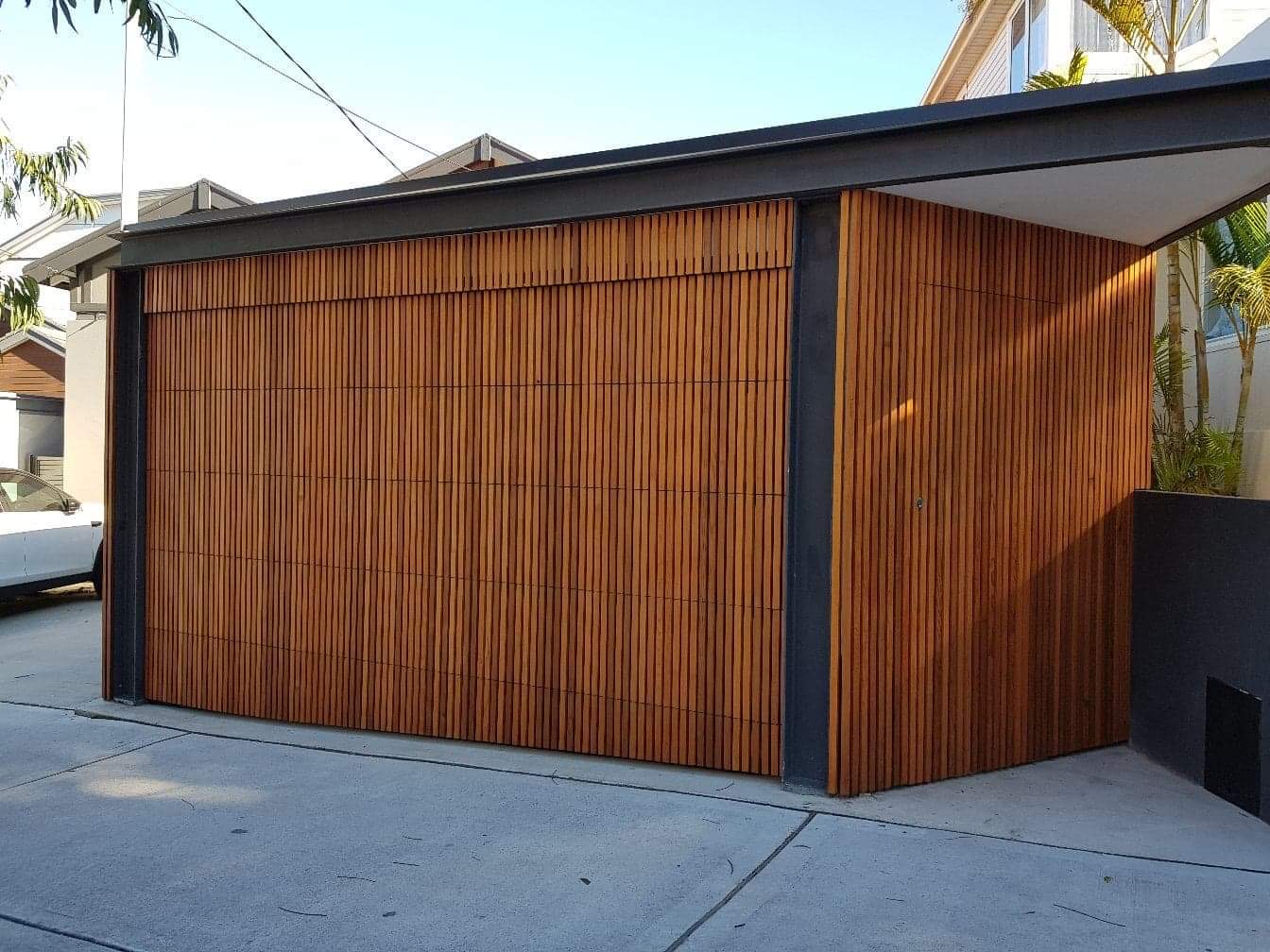 Cedar sectional garage door installation Auckland — warm timber finish